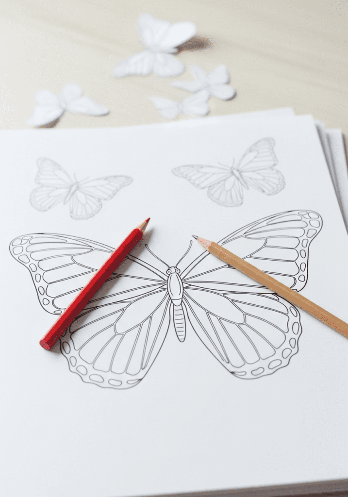 Simple line art of stacked printable coloring pages with crayons, hinting at a download.